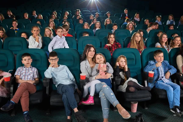 Children with parents enjoying a movie together at the cinema — Stock Photo, Image