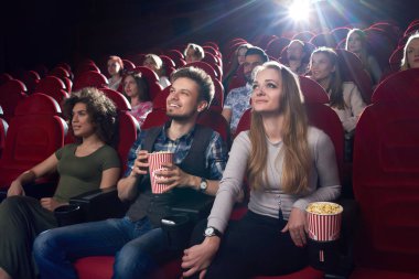 Komik film sinemada izlerken ve patlamış mısır yemek pozitif Çift.