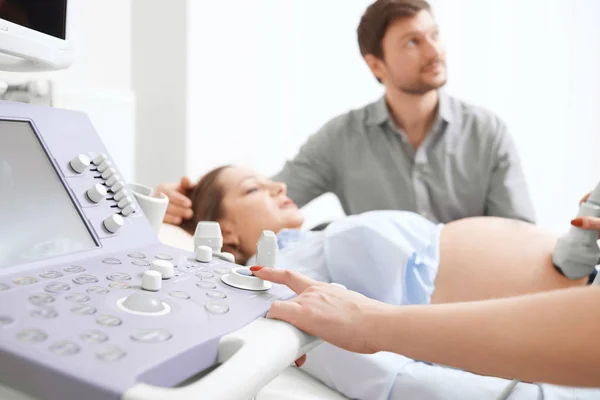 Врач проверяет беременную женщину и нажимает кнопки специального компьютера . — стоковое фото