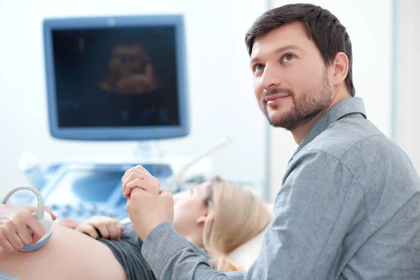 Mari portant sur sa femme enceinte à l'échographie dépistage . — Photo