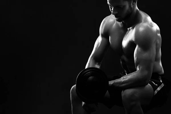Monochrome shot of an athletic ripped young sportsman with dumbb — Stock Photo, Image