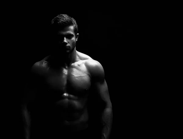 Genç kaslı sporcu üzerinde siyah adam gömleksiz poz yerleştirmek