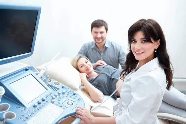 Professional doctor using ultrasound equipment screening pregnant woman.