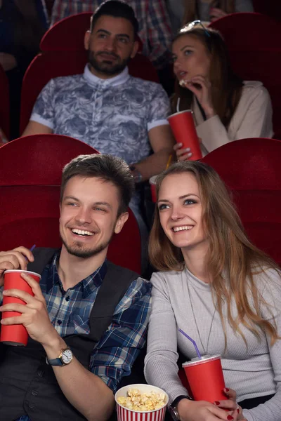 Boyfriend and girlfriend watching comedy at cinema together with friends. — Stock Photo, Image