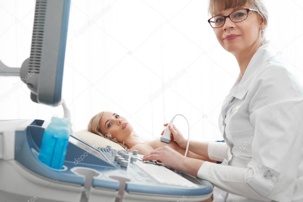 Young woman getting breast ultrasound scanning