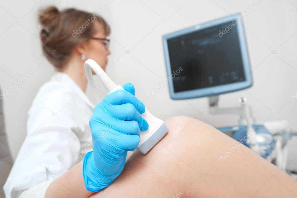 Woman getting knee ultrasound scanning examination at the clinic