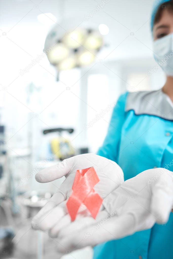 Female doctor holding breast cancer awareness pink ribbon