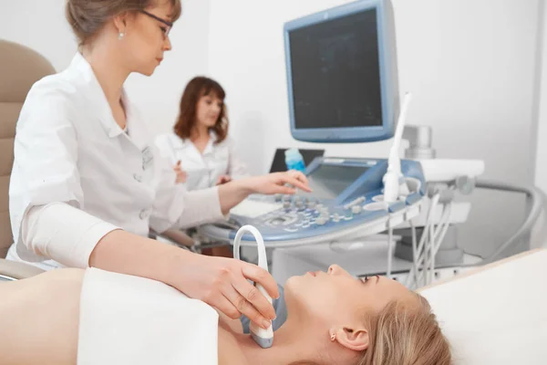 Junge Frau lässt sich im Krankenhaus per Ultraschall untersuchen Stockbild