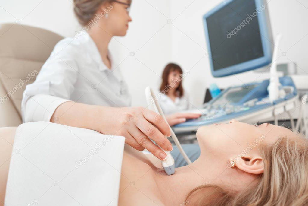 Young woman getting ultrasound scanning examination at the hospi