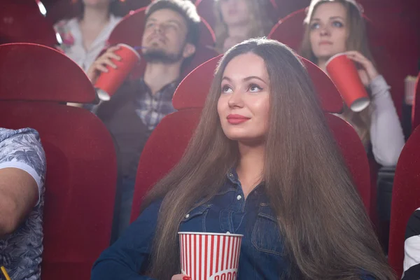 Νεαρή γυναίκα βλέποντας μια ταινία στο σινεμά — Φωτογραφία Αρχείου