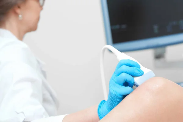 Mulher recebendo exame de ultra-som do joelho na clínica — Fotografia de Stock