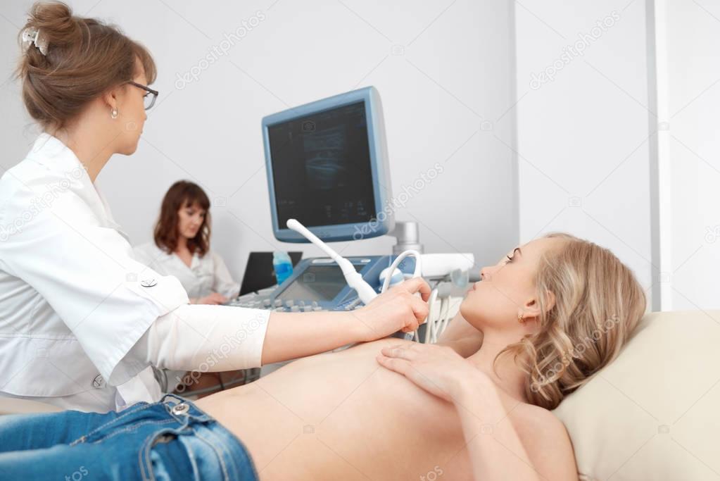 Young woman getting breast ultrasound scanning