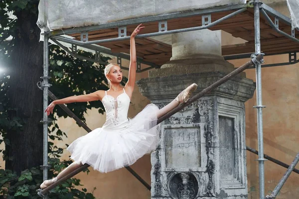 Балерина танцует возле строящегося здания — стоковое фото