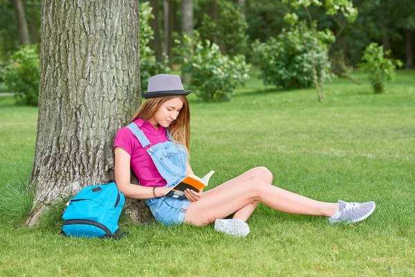 Joven hermosa mujer leyendo libro en el parque — Foto de Stock