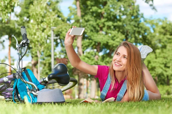 Junge Frau mit ihrem Smartphone im Park — Stockfoto
