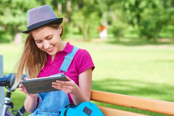 Wanita menggunakan tablet digital di taman — Stok Foto