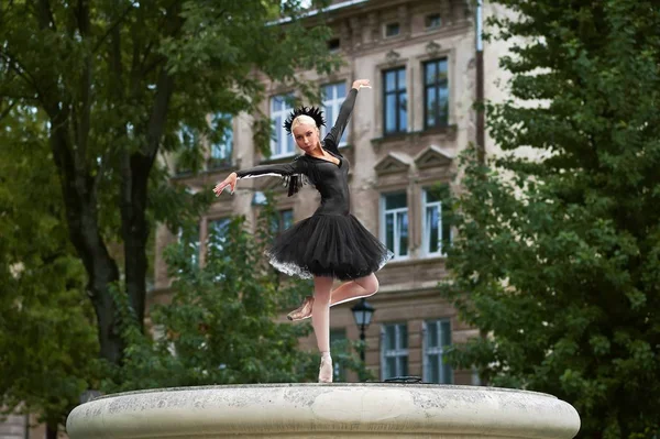 Hinreißende Ballerina im schwarzen Outfit tanzt in den Straßen der Stadt — Stockfoto