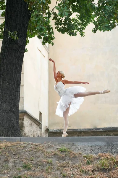 Schöne anmutige Ballerina, die auf den Straßen einer alten Stadt tanzt — Stockfoto