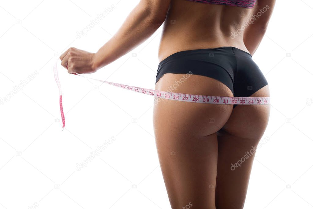 Beautiful sportswoman measuring her hips