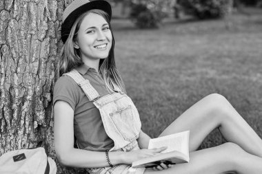 Genç güzel kadın parkta kitap okumak