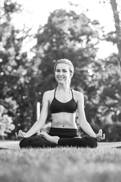 Jeune femme pratiquant le yoga en plein air au parc — Photo