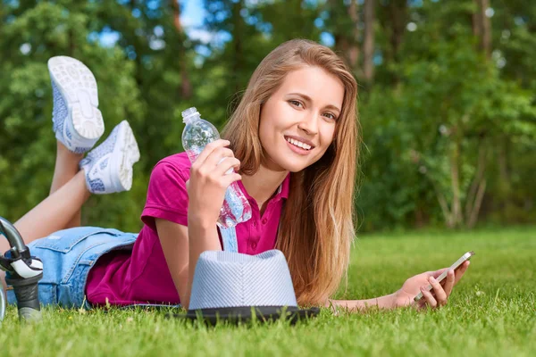 Junge Frau mit ihrem Smartphone im Park — Stockfoto
