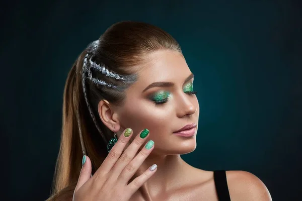 Beautiful brunette girl with stylish hairstyle and green shiny makeup.