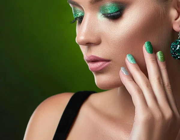 Hermosa morena con maquillaje verde brillante tocando perfecta piel de bronce . —  Fotos de Stock