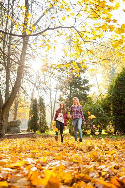 Mother and daughter walking through the forest holding hands — Stock Photo, Image