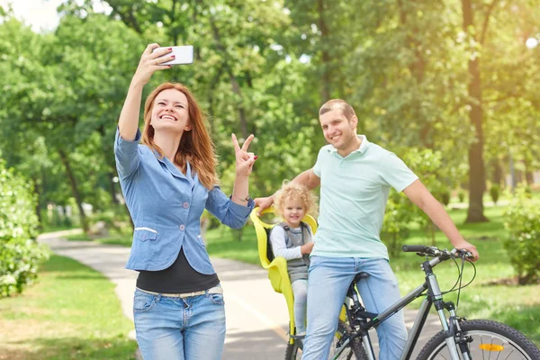 Happy family riding bike at the park — Stock Photo, Image