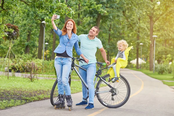 Happy family riding bike at the park — Stock Photo, Image