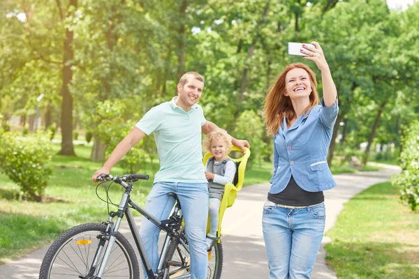 ครอบครัวที่มีความสุข ขี่จักรยานที่สวนสาธารณะ — ภาพถ่ายสต็อก