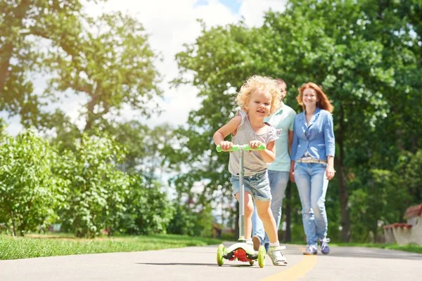 Little girl riding a scooter at the park — Stock Photo, Image