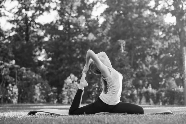 Jeune femme pratiquant le yoga en plein air au parc — Photo