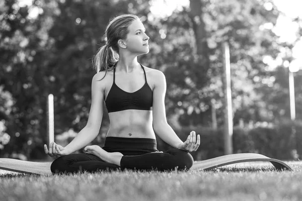 Jeune femme pratiquant le yoga en plein air au parc — Photo