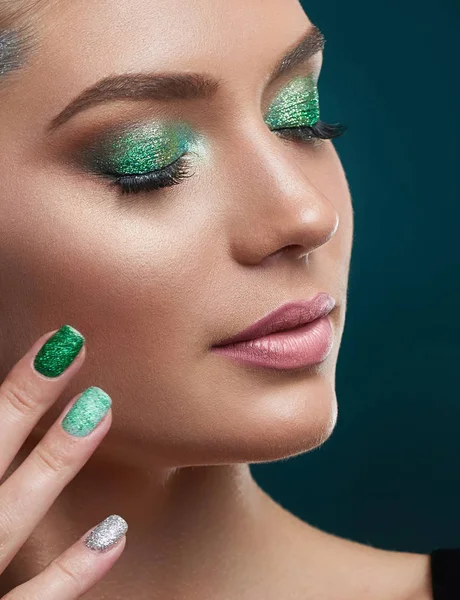 Fille à la peau parfaite, manucure brillante, maquillage aux couleurs vertes . — Photo