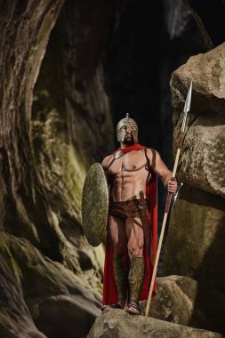 Kayaların üzerinde poz silah ile güçlü savaşçı