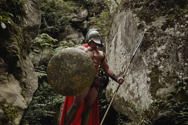 Segrande gladiator poserar med vapen — Stockfoto