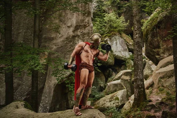 Bodybuilder im Gladiator-Outfit trainiert Bizeps — Stockfoto