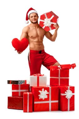 Yakışıklı Noel Baba hediyeleri yığını içinde ayakta