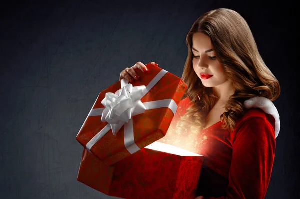 Sexy giovane donna in abito rosso di Babbo Natale con regali. Su un da — Foto Stock