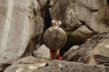 Kalkan ile saldırırken kapsayan gladyatör