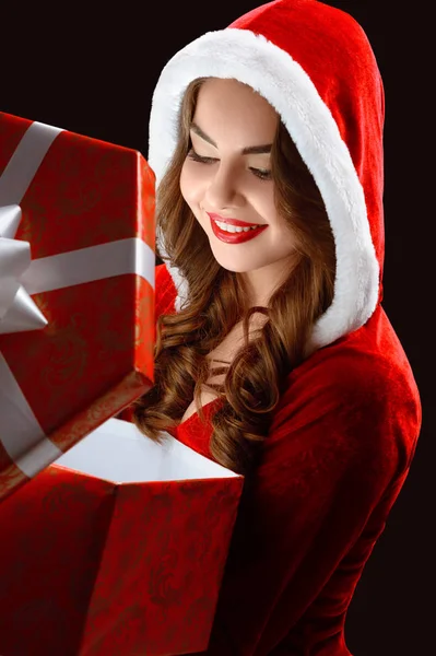 Retrato de niña sonriente en traje rojo, abriendo un regalo para Año Nuevo 2018,2019 . — Foto de Stock