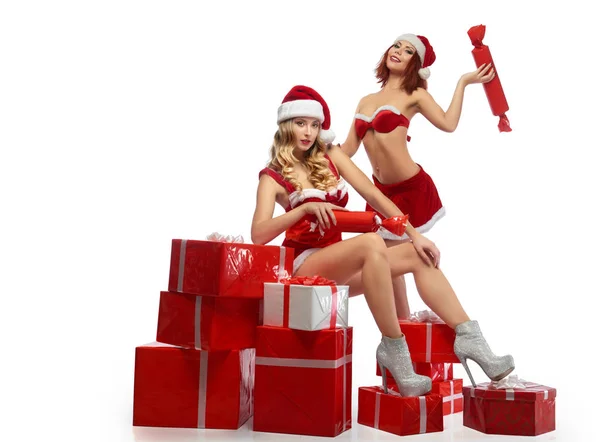 Due sexy ragazze di Natale in posa con un mucchio di regali — Foto Stock