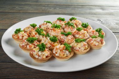 Olivier ve maydanoz ile bir tartlets ile servis tabağı.