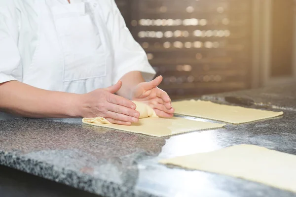 Baker hace algunos rollos de masa cruda y relleno — Foto de Stock