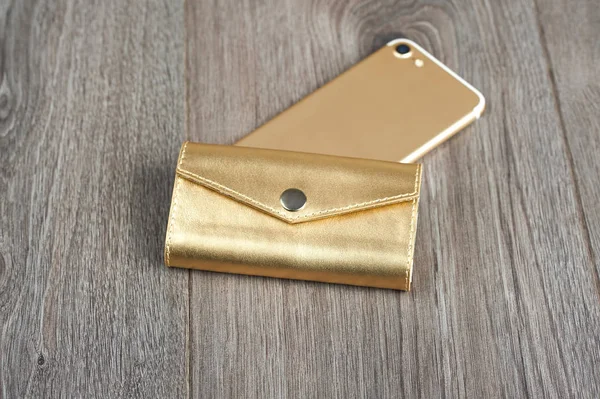 Χρυσή γυναίκα s υπόθεση με ένα Iphone σε μια ξύλινη επιφάνεια — Φωτογραφία Αρχείου