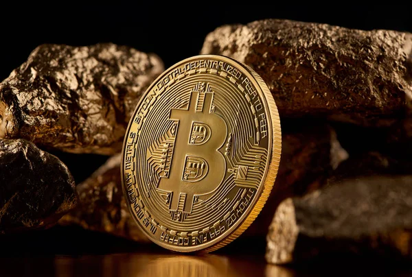 Golden bitcoin and gold lumps representing futuristic world trends both isolated on black background — Stock Photo, Image