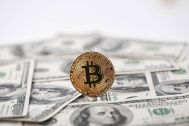 Yüz dolarlık banknotlar üzerinde arka plan ile altın bitcoin.