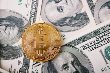 Yüz dolarlık banknotlar üzerinde arka plan ile dünya çapında en önemli cryptocurrency olarak altın bitcoin